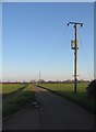 TL3671 : Chain Road & telegraph poles by Mr Ignavy
