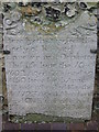 Old gravestone in the wall of St Peter