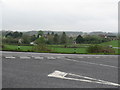 View across loop in road to houses near Manor Farm