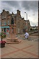 Boy on Bike Passing Water Fountain