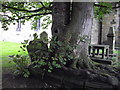 NY8464 : A tree in a grave in St. Cuthbert's Church, Graveyard by PAUL FARMER