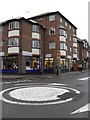 Looking across the mini-roundabout towards a charity shop