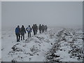 NZ6513 : Moorland trekkers in a snow storm by Philip Barker