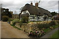 Thatched cottage and Ashton under Hill Church