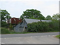 Dilapidated farm outbuildings by Taw Bridge Cross