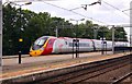 A Virgin train races through Wolverton Station