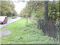 View along Oxford Road (A418) with gateway in the stone wall