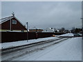 Approaching the crossroads of a snowy  Central Road and Station Road