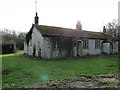 Pair of old, disused bungalows beside the footpath