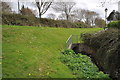 A stream emerges from under the A3125 at Roundswell