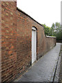 A brick wall in Mill Lane, and a bench mark