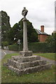 Village cross with old benchmark on face of top step