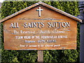 TM3046 : All Saints Church, Sutton sign by Geographer