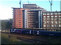 Train passing new apartments on approach to Manchester Victoria