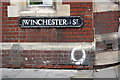 Benchmark and street name sign on Cross Keys House