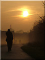 Two walkers and a jogger, in early morning mist