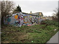 Graffiti filled wall beside the old rail line