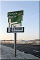 A wind-damaged sign on the A7