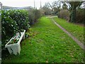 Seat with flowers provided on footpath at Hunston