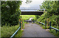 A walkway under the road with a footbridge beyond