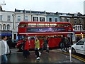 Red bus passing the junction of Compton and Wimbledon Hill Roads