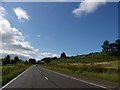 A71 approaching Strathaven with the pier of the railway bridge on either side of the road