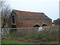 TL5296 : Unusual design of old brick barn by Richard Humphrey