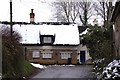 Snow covered thatched cottage on High Street