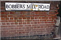 Benchmark on Bobbers Mill Road wall