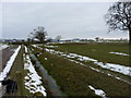 A bridge and stile across a drainage ditch