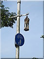 A candle holder hangs from a lamp post