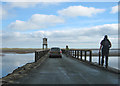 NU0842 : Walking over the causeway by Pauline E