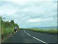 D3510 : A cyclist on the A2 with a view across the North Channel to Scotland by Eric Jones