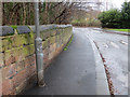 Higher Lane, Fazakerley, a sandstone wall, and a bench mark
