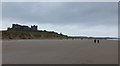 NU1835 : Walkers on the beach below Bamburgh Castle by Russel Wills