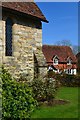 Corner of church with cottage beyond