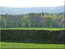 SK1285 : Edale: view across a wall towards the church spire by Chris Downer