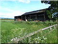 Barn with agricultural machinery beside Moor Lane