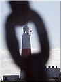 SY6768 : Bill of Portland: the lighthouse through a chain link by Chris Downer