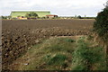 Farm buildings across the field from the footpath