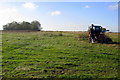 Farm machinery with Acre Spinney beyond