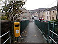 Yellow litter bin on a river footbridge in Maesteg