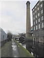 Turnbridge and Pedestrian Bridge over the Huddersfield Broad Canal with a mill and its chimney in Quay Street