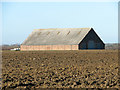 TG4107 : Big shed in crop field by Evelyn Simak