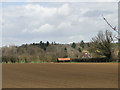 Red roofed black barn across the brown field