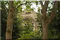 TQ2887 : View of the rose window of St. Joseph's Church framed by two trees in Waterlow Park by Robert Lamb