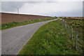 SH8459 : Road passing a wind turbine by Philip Halling