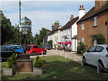 TQ6999 : Stock village sign and view past the Hoop Public House (listed building) by Roger Jones