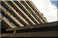 View of the Barbican apartment block intersecting the roof of The Postern from the area near the Barbican Estate