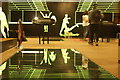 View of green neon light figures reflected in the floor of the Roman amphitheatre in the basement of the Guildhall Art Gallery